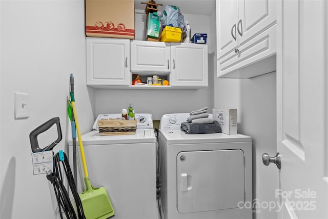 clothes washing area featuring washing machine and dryer and cabinet space