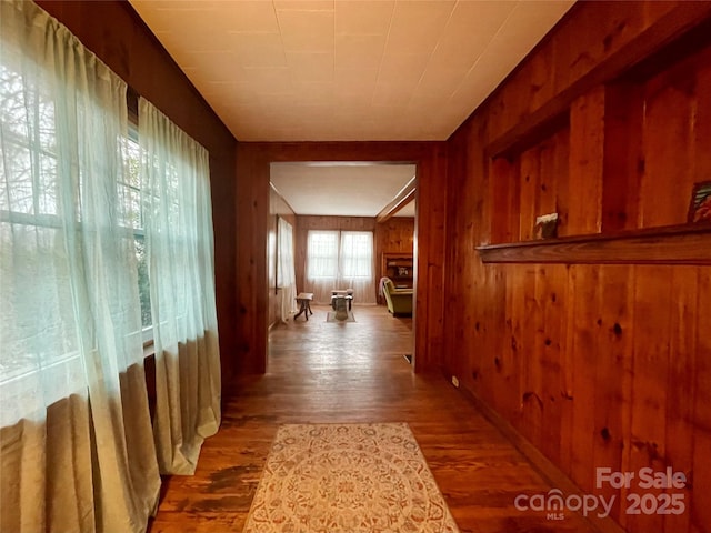 corridor featuring hardwood / wood-style flooring and wood walls