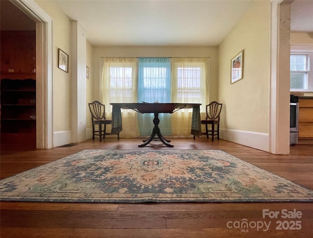 living area with hardwood / wood-style flooring and a healthy amount of sunlight