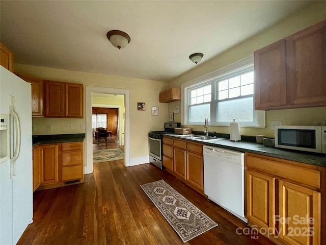 kitchen with white appliances, dark hardwood / wood-style flooring, and sink