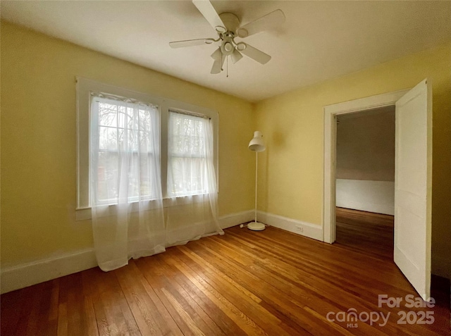 spare room featuring wood-type flooring and ceiling fan