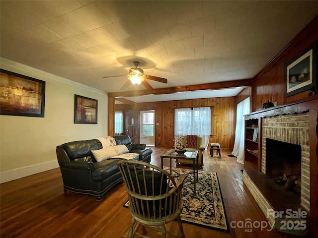 living room featuring a brick fireplace, wooden walls, dark hardwood / wood-style floors, and ceiling fan