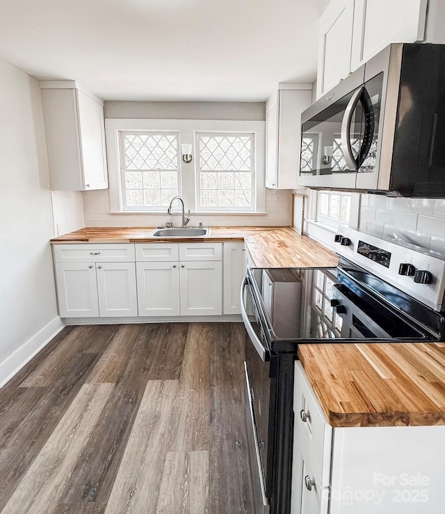 kitchen featuring sink, butcher block counters, white cabinetry, stainless steel appliances, and tasteful backsplash