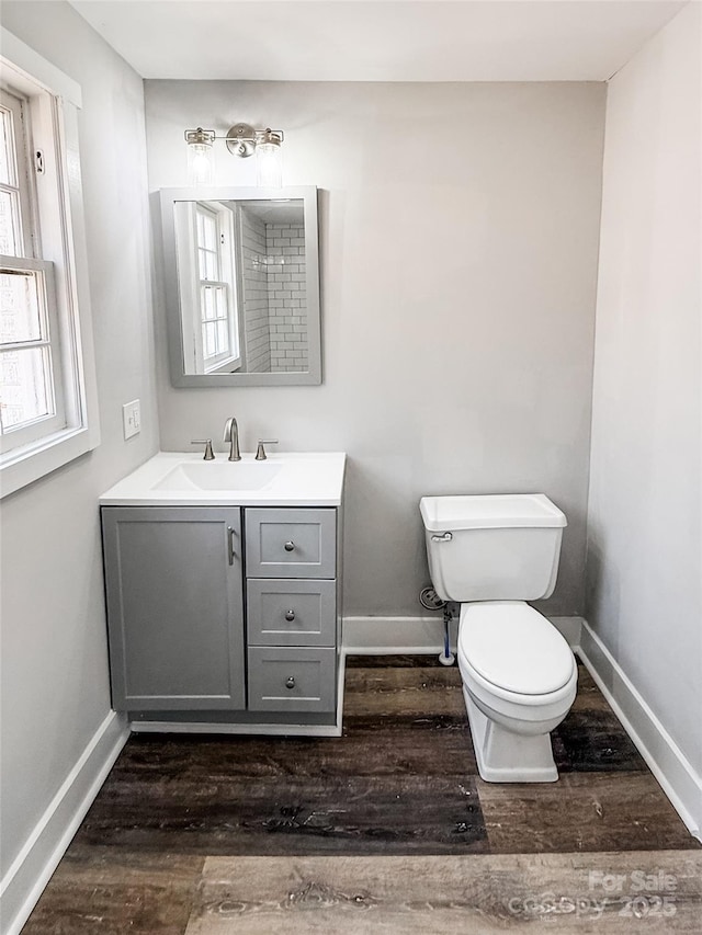bathroom featuring wood-type flooring, toilet, and vanity