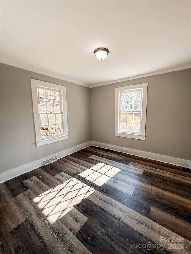 empty room featuring crown molding and dark hardwood / wood-style flooring