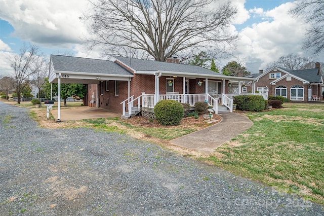 view of front of property featuring an attached carport, brick siding, a shingled roof, driveway, and a chimney