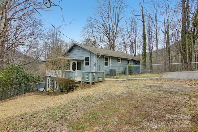 rear view of house featuring central AC unit, a gate, and a fenced backyard