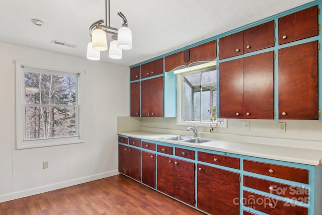 kitchen featuring a sink, visible vents, plenty of natural light, and dark wood-type flooring