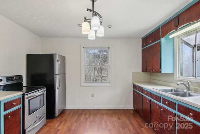 kitchen featuring a sink, light countertops, dark wood finished floors, and stainless steel appliances