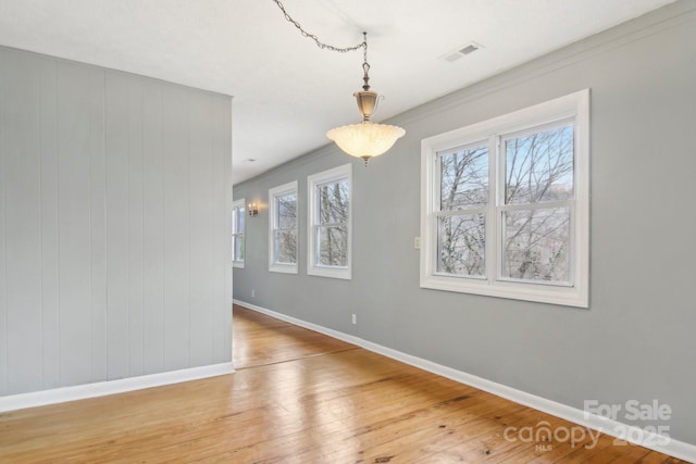 unfurnished dining area featuring visible vents, baseboards, and light wood-style floors