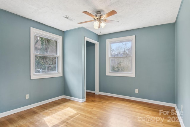 unfurnished bedroom with visible vents, multiple windows, and light wood finished floors