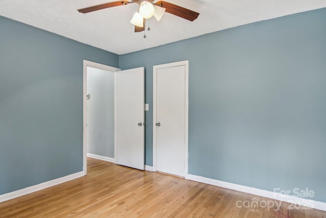 unfurnished bedroom featuring ceiling fan, baseboards, and hardwood / wood-style floors