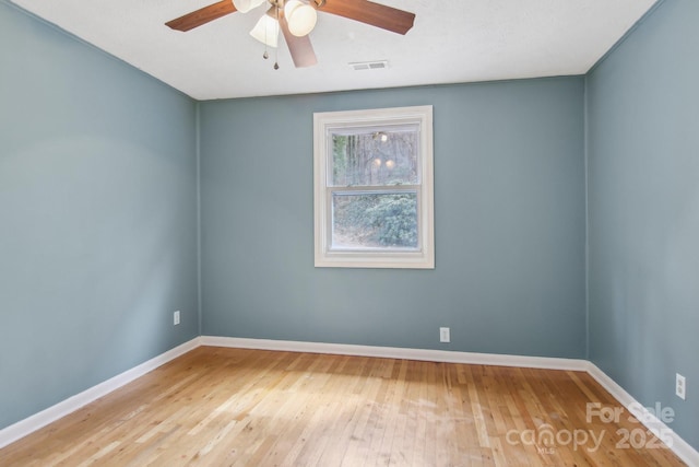 spare room featuring visible vents, wood-type flooring, baseboards, and ceiling fan