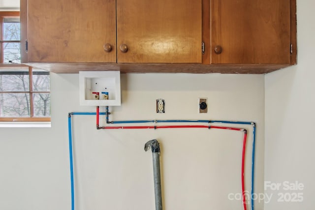 clothes washing area featuring water heater, cabinet space, hookup for an electric dryer, and washer hookup