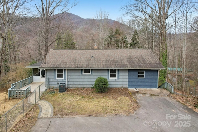 view of front of property with a mountain view, driveway, and roof with shingles