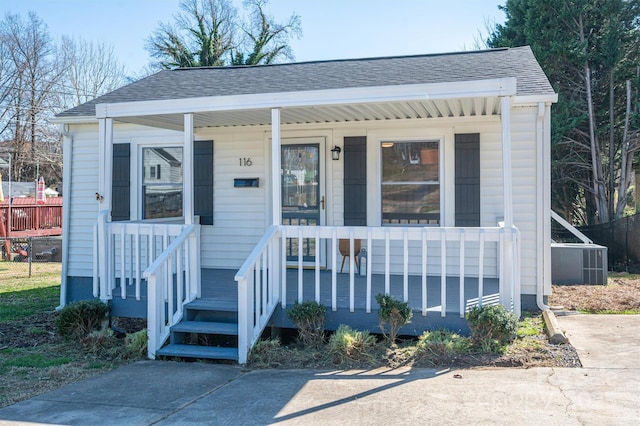 bungalow-style house with a porch and roof with shingles