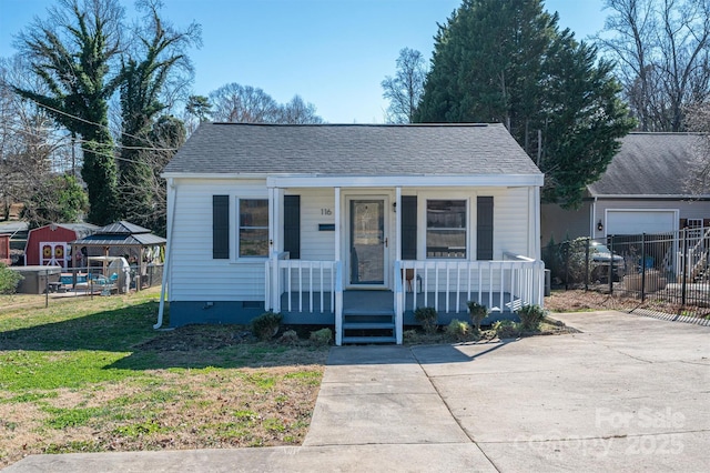 bungalow-style house with roof with shingles, a porch, crawl space, fence, and a front lawn