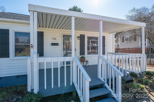 entrance to property featuring covered porch, roof with shingles, and crawl space