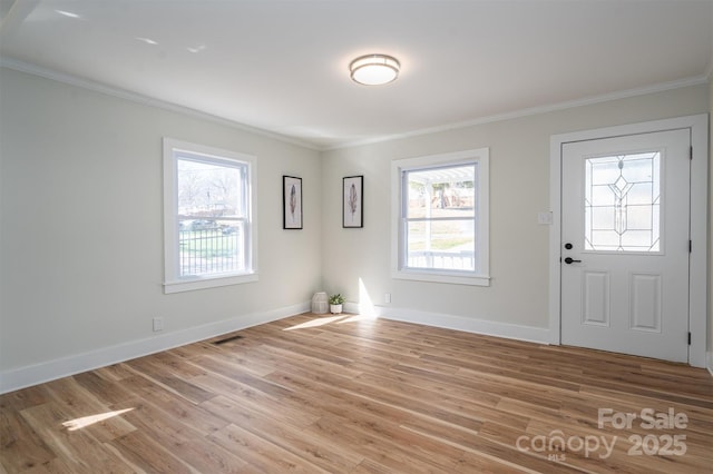 entryway featuring baseboards, ornamental molding, visible vents, and light wood-style floors