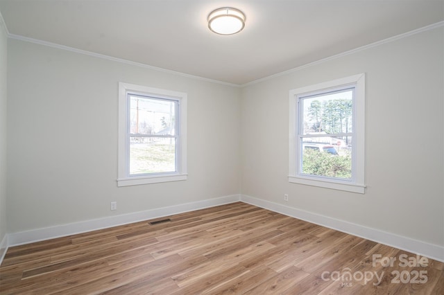 spare room featuring a healthy amount of sunlight, visible vents, and ornamental molding