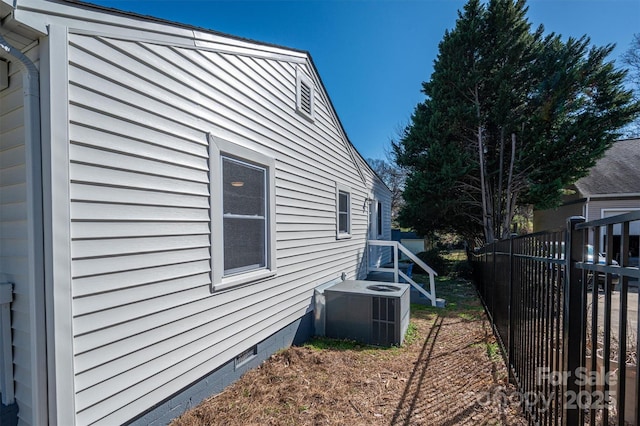 view of home's exterior with crawl space, central air condition unit, and fence