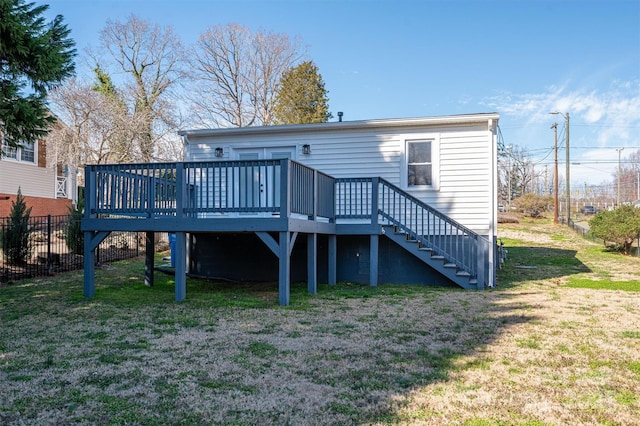 rear view of house featuring a yard, stairway, a wooden deck, and fence