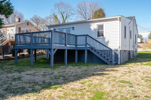 back of property with a yard, a deck, and stairs