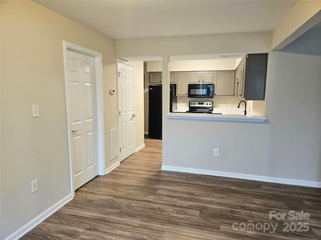 kitchen featuring gray cabinets, black appliances, sink, kitchen peninsula, and dark wood-type flooring