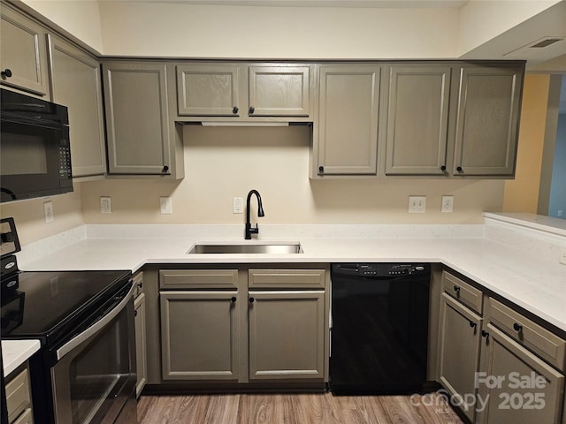 kitchen featuring gray cabinetry, sink, and black appliances