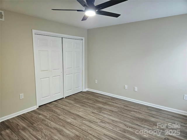 unfurnished bedroom featuring hardwood / wood-style floors, a closet, and ceiling fan