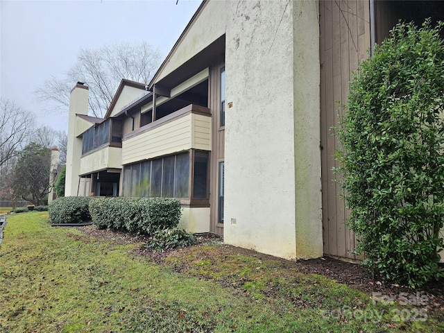 view of side of property with a lawn