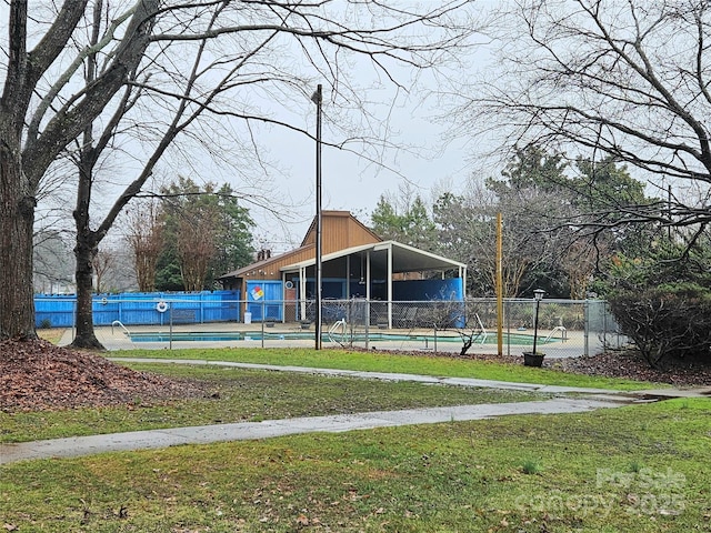 view of property's community featuring a swimming pool and a yard