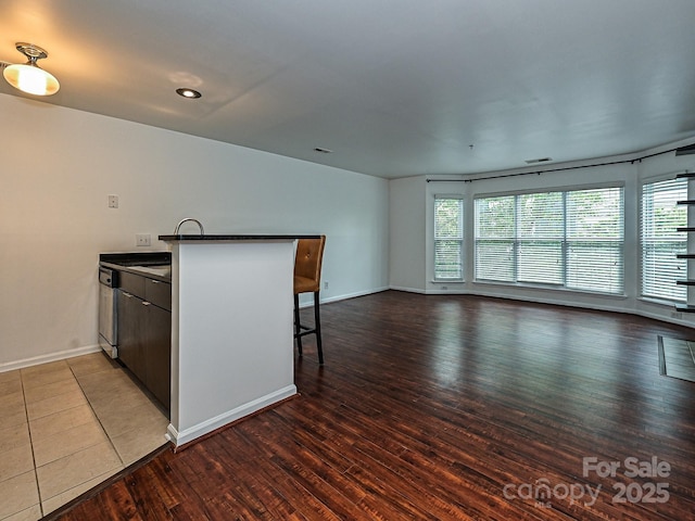 kitchen featuring dark hardwood / wood-style floors, plenty of natural light, a kitchen breakfast bar, and kitchen peninsula