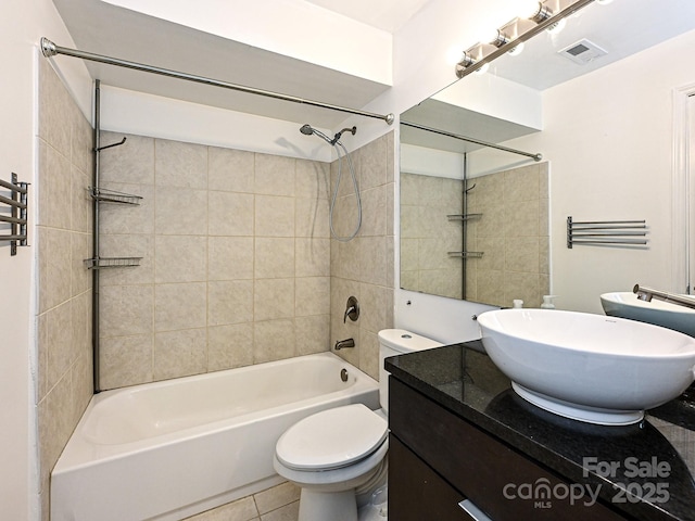 full bathroom featuring vanity, toilet, tiled shower / bath combo, and tile patterned flooring