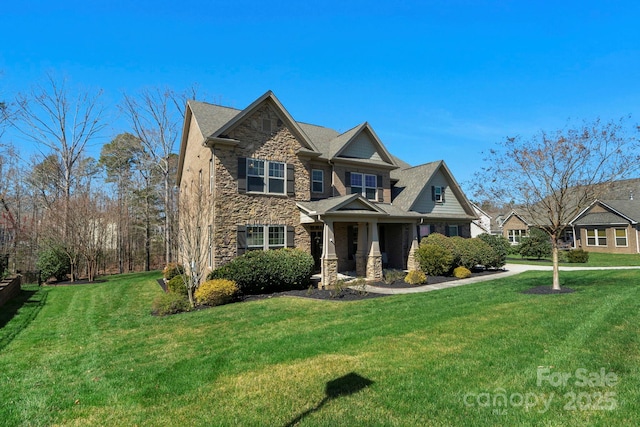 view of front facade with stone siding and a front lawn