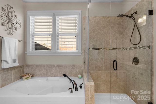 bathroom featuring a shower stall and a garden tub