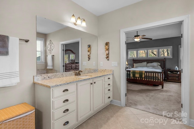 ensuite bathroom featuring a ceiling fan, ensuite bath, tile patterned flooring, baseboards, and vanity