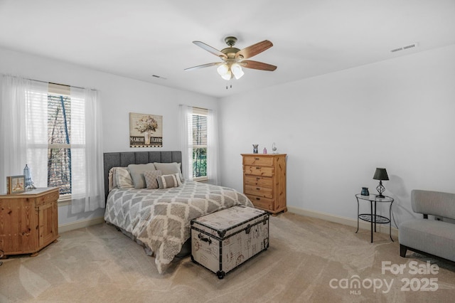 bedroom featuring light carpet, visible vents, multiple windows, and baseboards