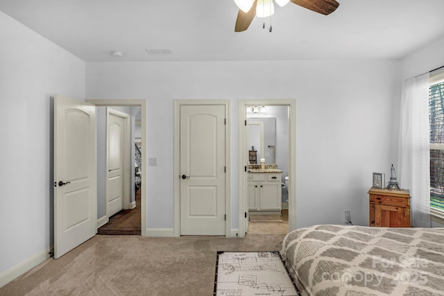 bedroom with light carpet, visible vents, connected bathroom, and baseboards