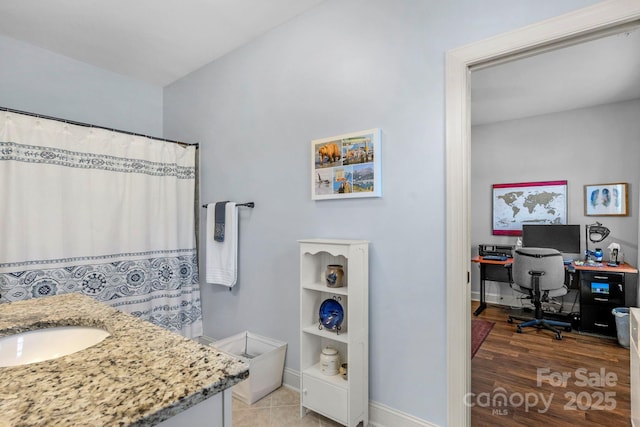 full bathroom with vanity, a shower with shower curtain, wood finished floors, and baseboards