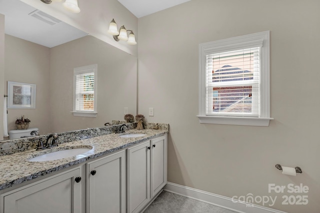 bathroom with double vanity, toilet, visible vents, and a sink