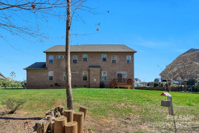 rear view of property featuring crawl space, a lawn, and brick siding