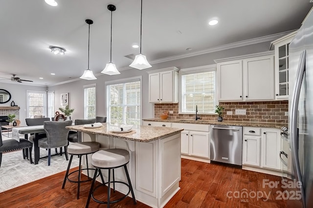 kitchen with stainless steel appliances, a center island, glass insert cabinets, and white cabinetry