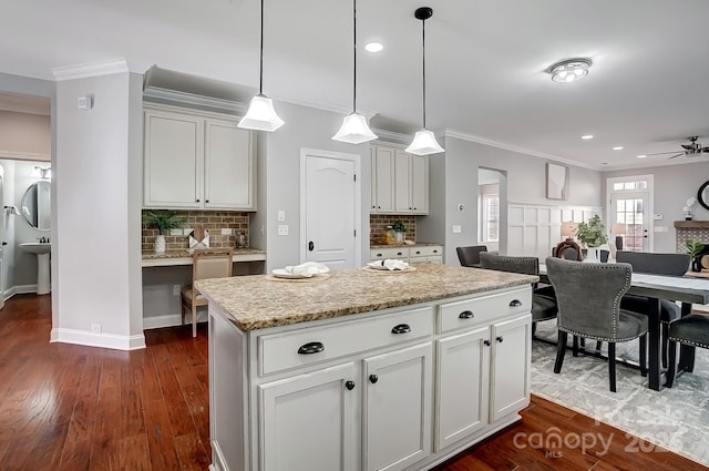 kitchen with a kitchen island, white cabinetry, pendant lighting, and open floor plan