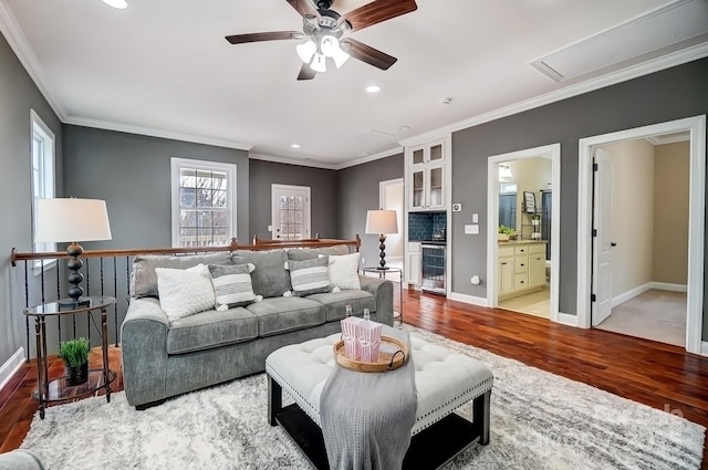 living room featuring ornamental molding, baseboards, and wood finished floors