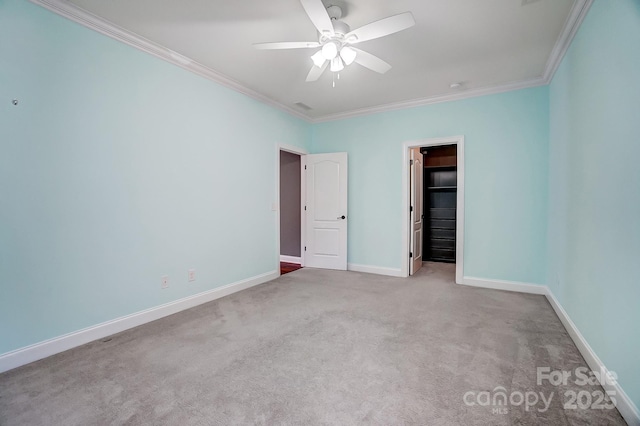 unfurnished room featuring a ceiling fan, baseboards, crown molding, and light colored carpet