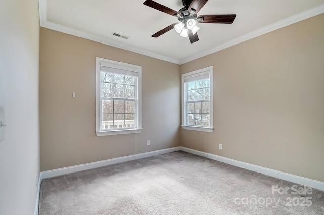 carpeted empty room featuring a ceiling fan, visible vents, crown molding, and baseboards