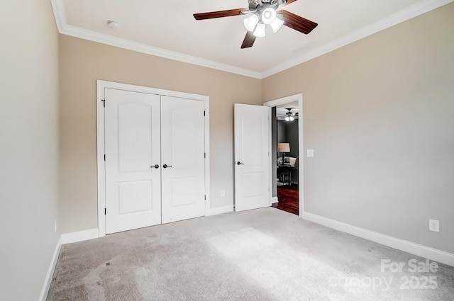 unfurnished bedroom featuring baseboards, ceiling fan, ornamental molding, carpet, and a closet