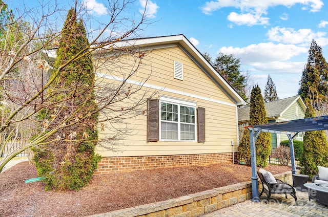 view of home's exterior with a patio and a pergola