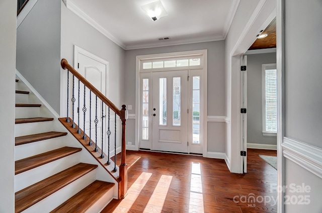 entrance foyer with stairs, wood-type flooring, visible vents, and crown molding